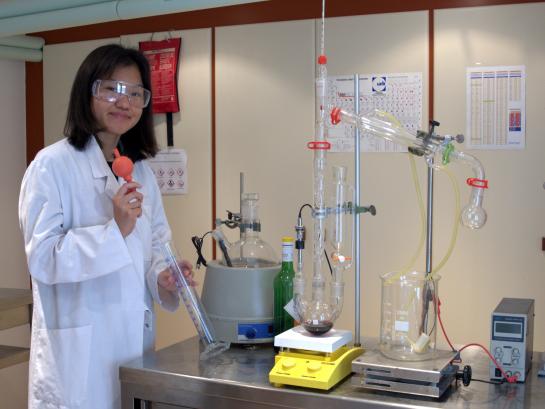 Een leerling pippeteert in het chemie labo.